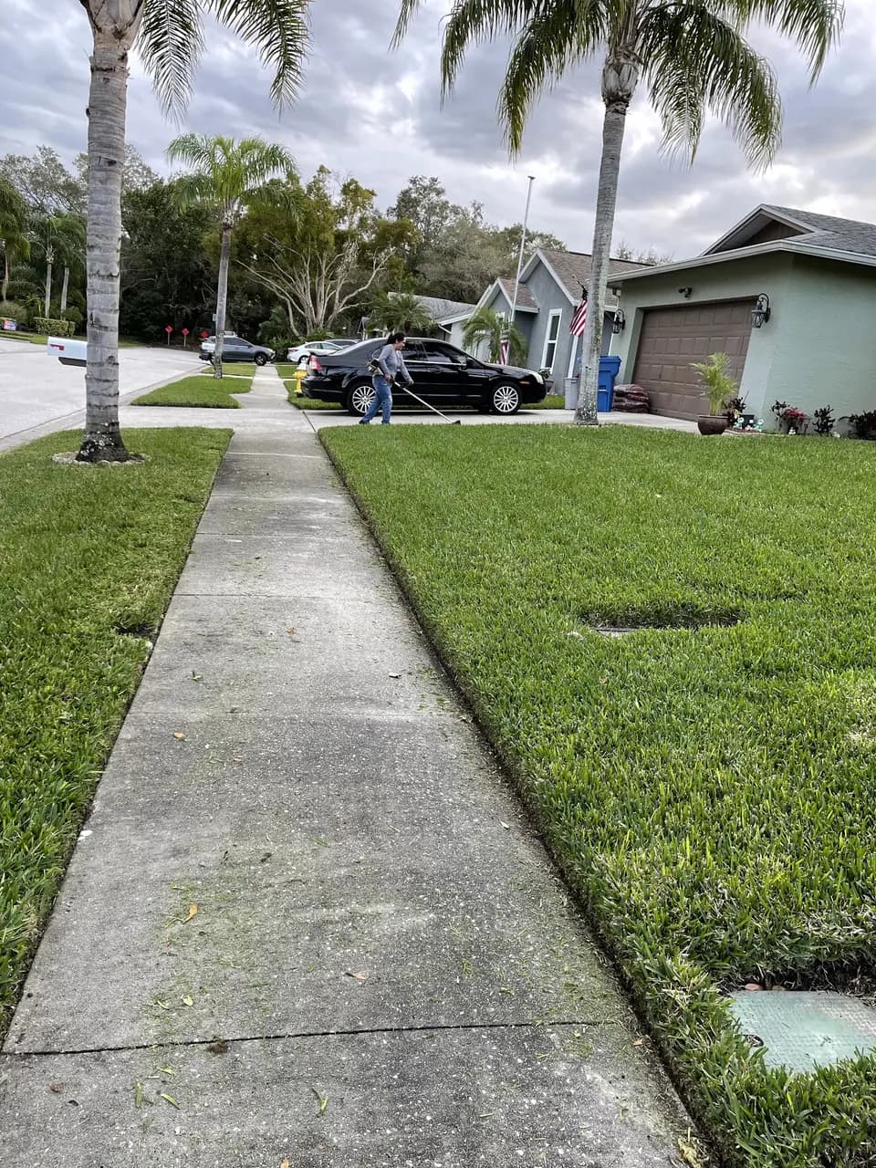 Sidewalk with crisp lawn edging on both sides down a residential street