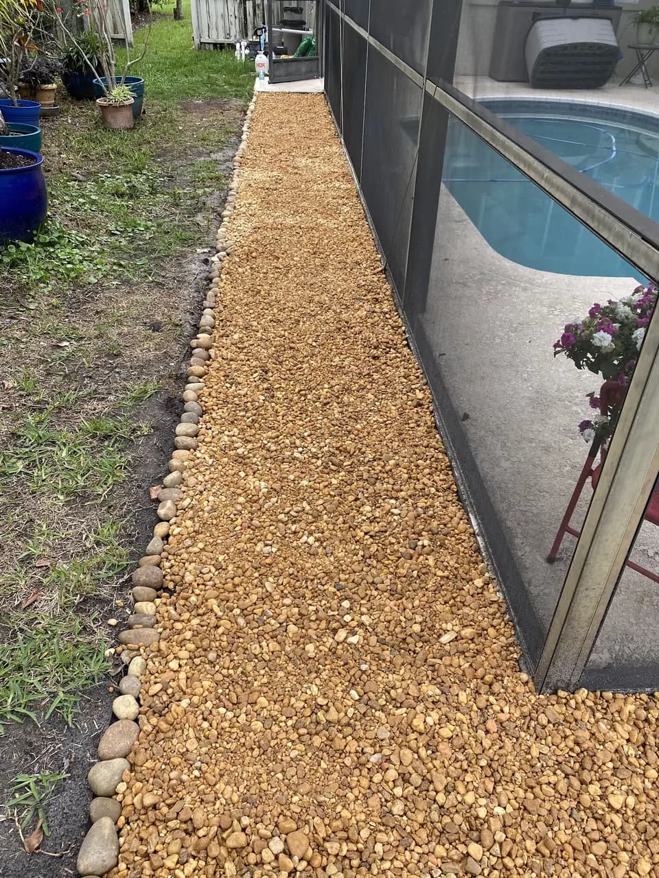 Gravel path running along a screened pool